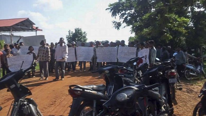 People hold placards as they block a road in Battambang province earlier this month during a protest regarding an ongoing land dispute.